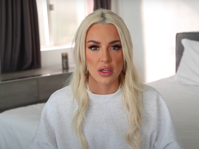 Tana Mongeau In White Outfit Sitting On Bed