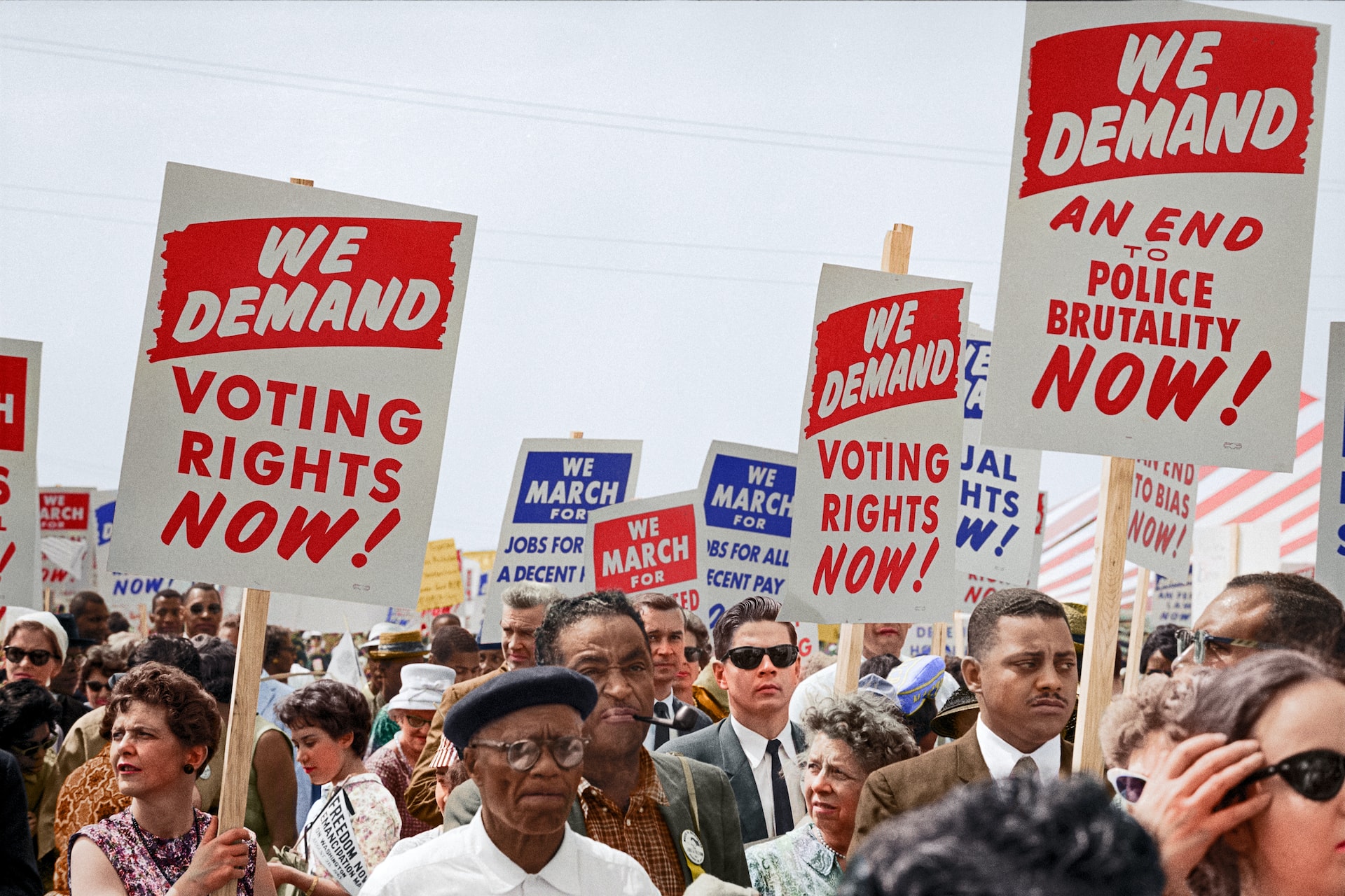 Black protesters in Washington in 1963 carrying placards with the words ‘we demand voting rights now’