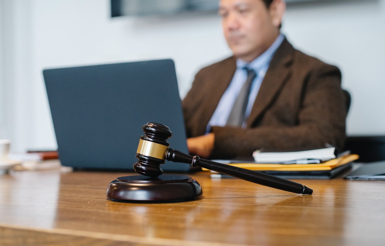 Contemplative Asian lawyer working on laptop in law firm