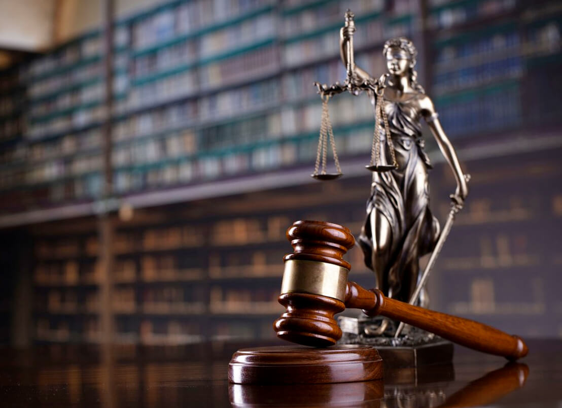 A wooden gavel and lady justice statue